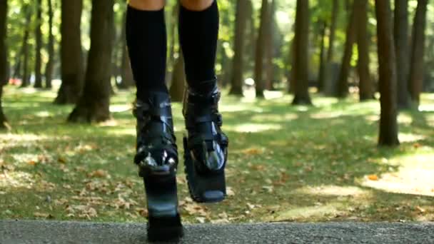 The girl is engaged in fitness in the forest. Coach for Kangoo Jump. A popular kind of aerobics — Stock Video