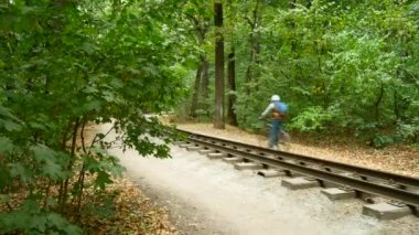 Demiryolu sonbahar ormanda yol boyunca yalnız bir bisikletçi sürücüler.