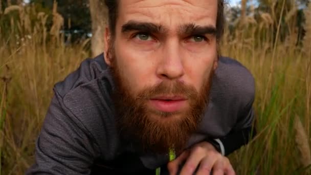 Een man sluipt door het gras. Een bange jongen kijkt vooruit. — Stockvideo