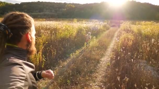 La chica y papá están jugando en el campo. Papá está alcanzando a su hija. Valores familiares. Luz del atardecer. Vídeo en cámara lenta . — Vídeo de stock