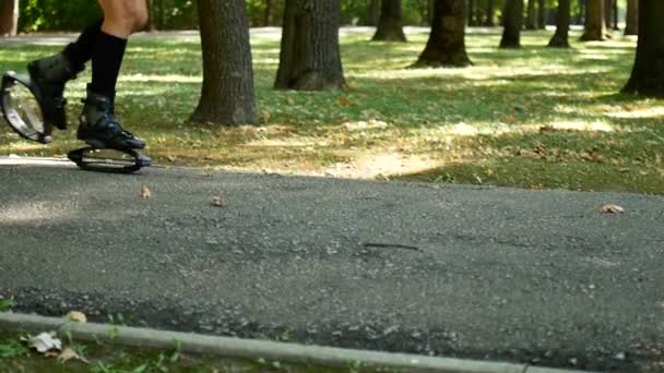 Ung vacker flicka gör sport i parken. En kvinna hoppar på speciella skor för fitness. — Stockvideo