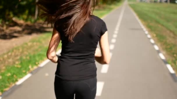 Krásná mladá dívka sportovat v parku. Žena skáče na speciální boty pro fitness. — Stock video