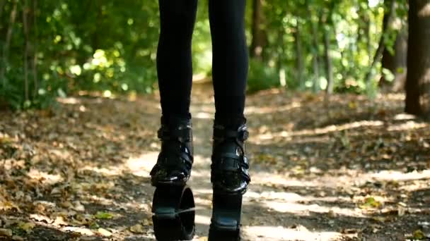 年轻漂亮的女孩在公园里锻炼。一个女人跳上特别的鞋，健身. — 图库视频影像