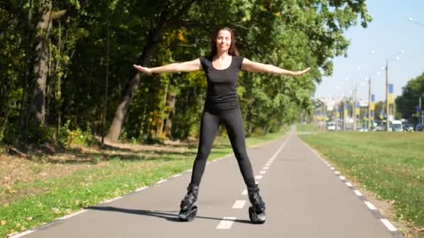 Молода красива дівчина займається спортом у парку. Жінка стрибає на спеціальне взуття для фітнесу . — стокове відео