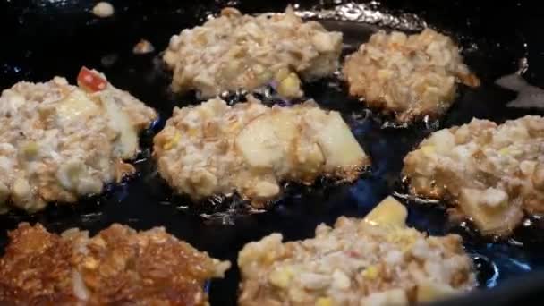 Le cuisinier prépare les escalopes dans une poêle. Les petites crêpes sont frites à l'huile . — Video