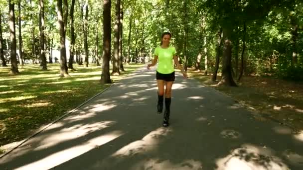 Joven chica hermosa haciendo deportes en el parque. Una mujer salta en zapatos especiales para la aptitud . — Vídeo de stock