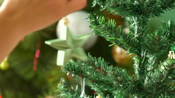 Christbaumschmuck für das neue Jahr. der Neujahrsstern wird an einen Baum gehängt. — Stockvideo