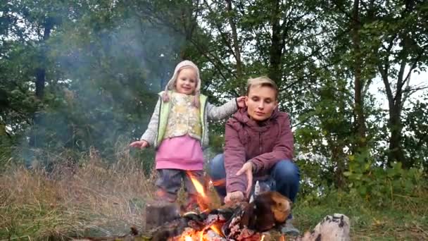 Moeder en dochter koken voedsel op de brandstapel. Familie picknick, weekend. — Stockvideo