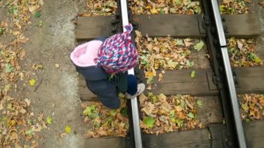 Küçük kız düzgünce tren yolu haçlar. Video üst nokta.