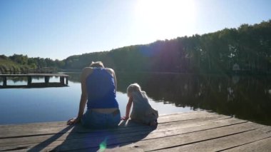 Anne ve kızı iskelede ve doğanın tadını çıkarın. Aile tatilleri.