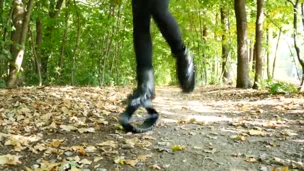 Jovem menina bonita fazendo esportes no parque. Uma mulher pula em sapatos especiais para a aptidão . — Vídeo de Stock