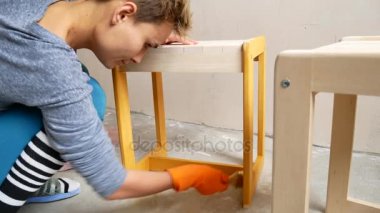 Bir kız bir sandalye boyuyor. Kendi ellerinle dairede onarmak.