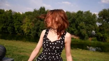 Genç bir kadın kısa etek elbise bir su birikintisi sahilde yürüyor. Kız iplik ve having fun.