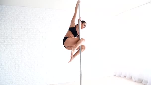 El atleta hace trucos en el pilón. Una hermosa chica fuerte se está entrenando en la danza polaca . — Vídeos de Stock