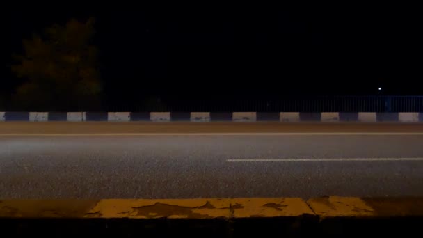 Tráfico nocturno en la carretera. Los coches pasan e iluminan la carretera . — Vídeos de Stock