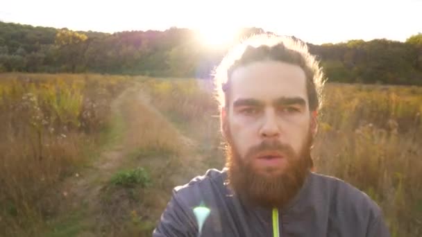 Herfst joggen. Een man in opleiding op de vlucht. Portret van een loper in slow motion. — Stockvideo