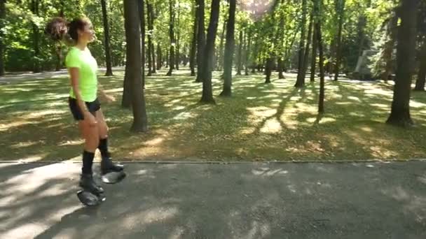 Mooi meisje sport in het park te doen. Een vrouw springt op speciale schoenen voor fitness. — Stockvideo