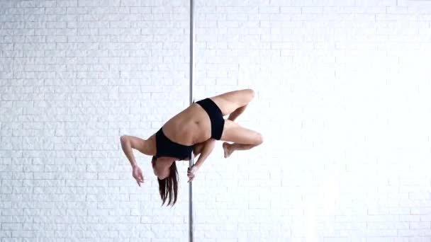 O atleta faz truques no pilão. Uma bela garota forte está treinando no Pole Dance . — Vídeo de Stock