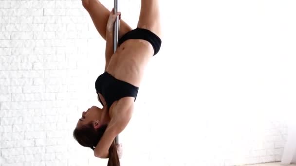 De atleet maakt trucs op de pyloon. Een mooie sterke meisje is opleiding in de Pole Dance. — Stockvideo