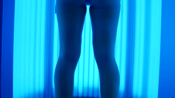 The girl dances in a vertical solarium. Young woman having fun and sunbathing. — Stock Video