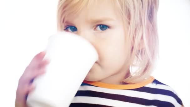 Un bambino beve un drink da un bicchiere di carta. Video su sfondo chiaro . — Video Stock