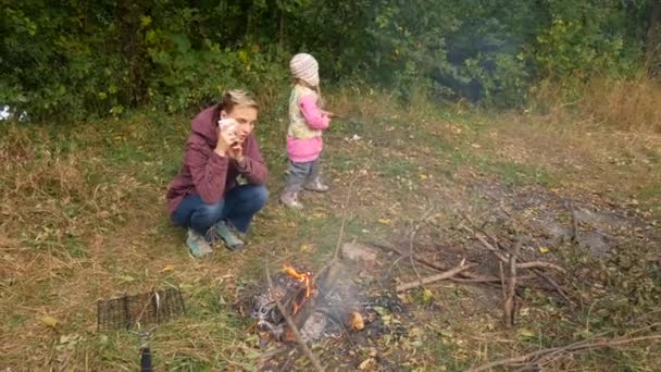 Mamá e hija cocinan comida en la hoguera. Picnic familiar, fin de semana . — Vídeos de Stock