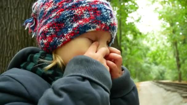 Bambino triste nella foresta autunnale. La ragazza è sconvolta e sorride alla telecamera . — Video Stock