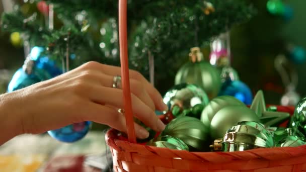 Zdobení vánočního stromku. Dívka bere kuličky z koše — Stock video