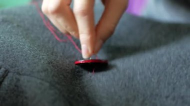 Terzi bir düğme onun giysilerini diker. İğne işi ve küçük giyim onarım