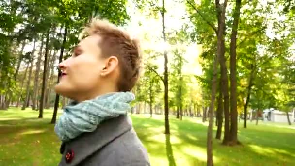 Porträtt av en flicka i solen. Promenad i parken hösten. — Stockvideo