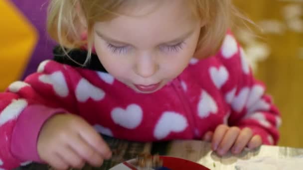 Ένα μικρό κορίτσι τρώει κουάκερ φαγόπυρου. Το παιδί τρώει πρόθυμα. — Αρχείο Βίντεο