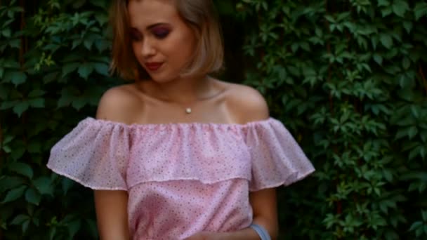 Girl on a green background. Young beautiful woman in a city outfit — Stock Video