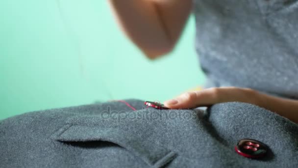 De naaister naait een knop op haar kleren. Handwerk en kleine kleding reparatie — Stockvideo