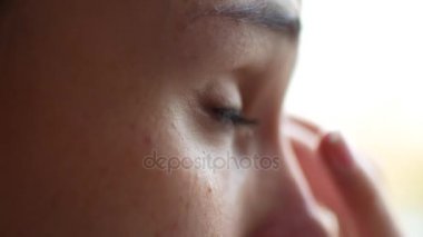 Bir kız depresyon bir pencere oturuyor. O gözyaşları gözlerinden, mendil yakın çekim