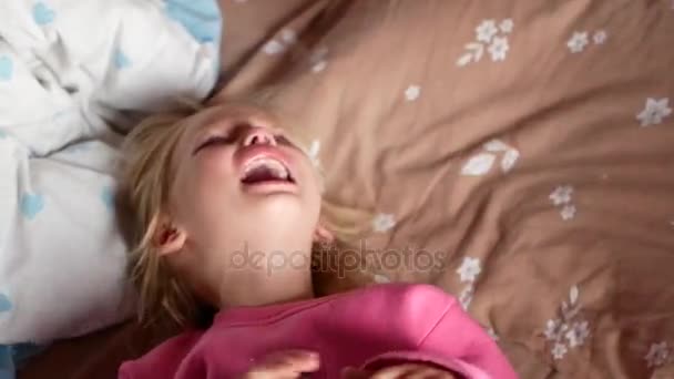 Una bambina sta piangendo sul letto. Il bambino è molto turbato, ha l'isterica. — Video Stock