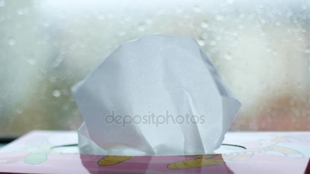 Una mano de mujer saca las servilletas de la caja. La caja se encuentra en el alféizar de la ventana, fuera de la ventana está lloviendo — Vídeos de Stock