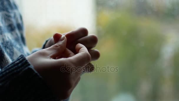 Nervöser müder Zustand. berührt das Mädchen ihre Finger, sie ist aufgeregt. Es regnet draußen vor dem Fenster. Vielleicht wartet sie auf einen geliebten Menschen — Stockvideo