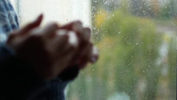 Estado nervioso cansado. La chica se toca los dedos, está emocionada. Está lloviendo fuera de la ventana. Tal vez ella está esperando a un ser querido — Vídeos de Stock