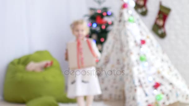 The child is carrying a gift to the camera. Christmas mood, the time of miracles and gifts — Stock Video