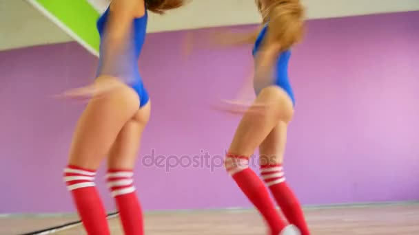 Chicas en trajes azules bailan sobre el fondo de una pared púrpura. Bailes modernos, chicas hermosas calientes — Vídeos de Stock