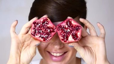 Parlak makyajlı kız modeli. Elinde Nar ile kırmızı meyve ile kız