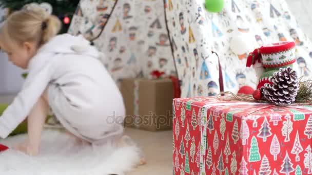 La chica está jugando en la cabaña de los niños. Humor de Navidad, regalos en primer plano — Vídeo de stock