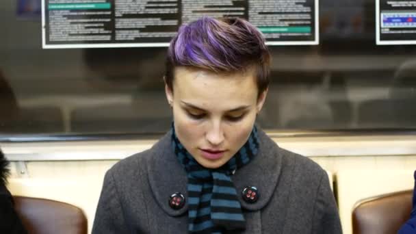 Девушка читает книгу в машине метро — стоковое видео