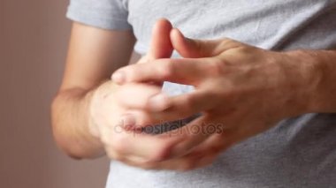 Sedef hastalığı olan bir adam elinde. Parantezi gergin ve ellerini çizikler