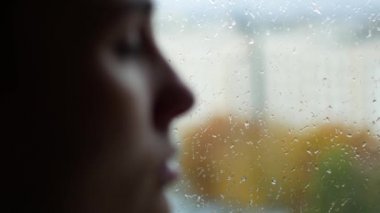 Bir kadın bir burun akıntısı var. Genç bir kız onun yağmur bir pencere oturuyor dışında. Depresyon