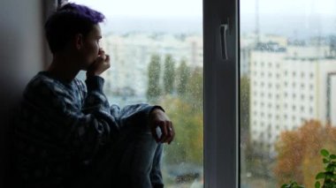 Bir kadın bir burun akıntısı var. Genç bir kız onun yağmur bir pencere oturuyor dışında. Depresyon