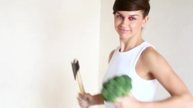Bir elinde bir balta ile ve diğer bir brokoli ile kız dansları