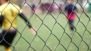Metal çitin arkasında futbolcu. Islah Kurum