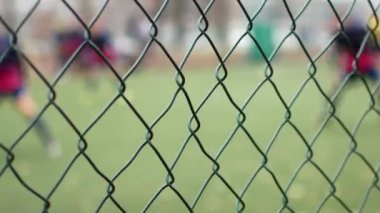 Metal çitin arkasında futbolcu. Islah Kurum