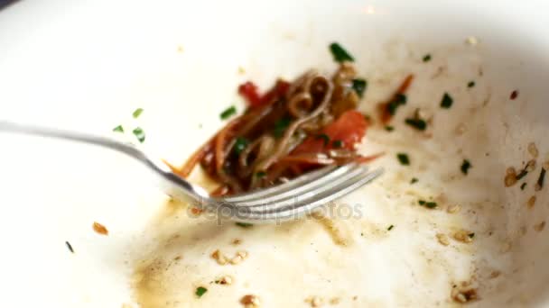 Un uomo sta mangiando tagliatelle asiatiche con verdure con una forchetta — Video Stock